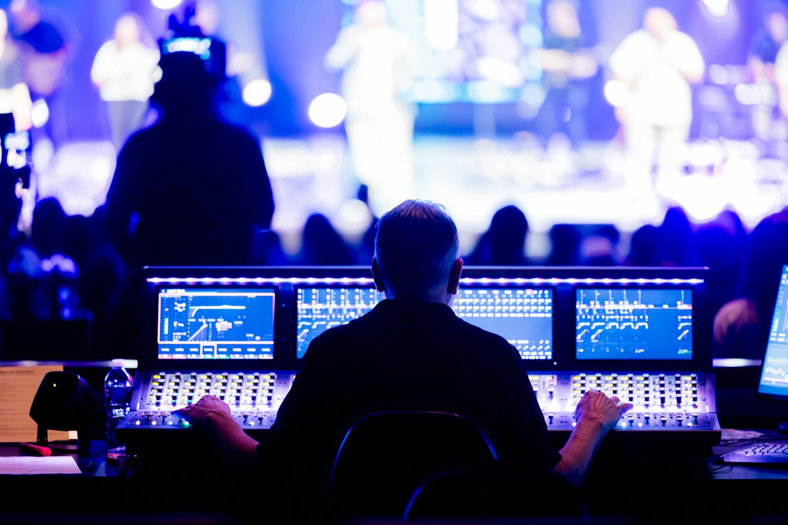Technician operating a mixing console at a live event